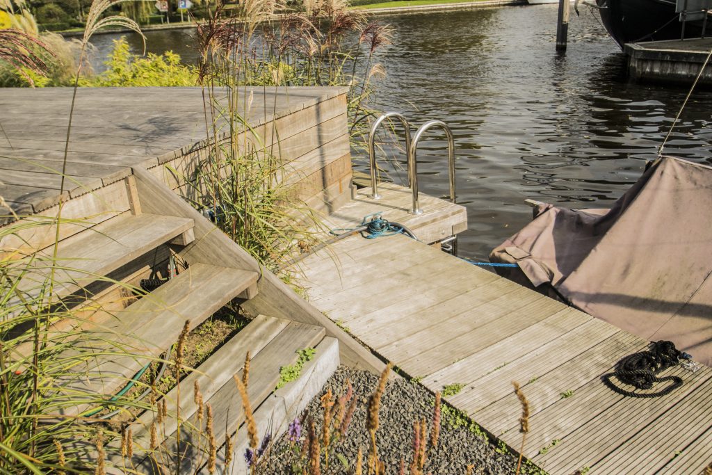 Houten vlonder steiger met trap en reling aan het water, aangelegd door Bouma Waterwerken.