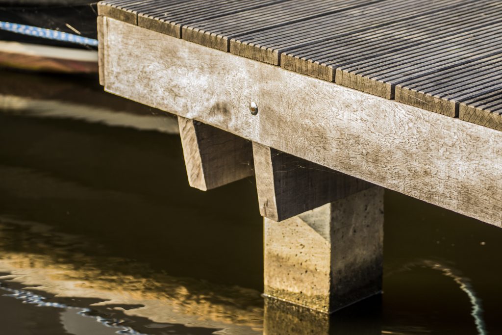 Betonnen steiger met houten dek op betonnen palen in het water, uitgevoerd door Bouma Waterwerken.