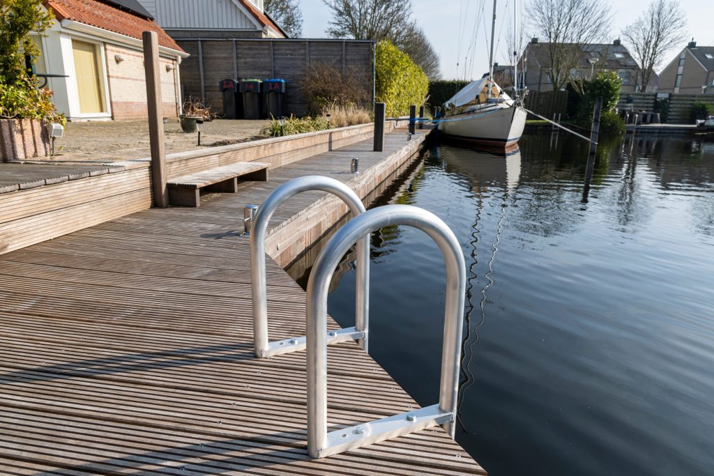Hardhouten vlondersteiger met RVS zwemtrap aan het water, professioneel aangelegd met modern design