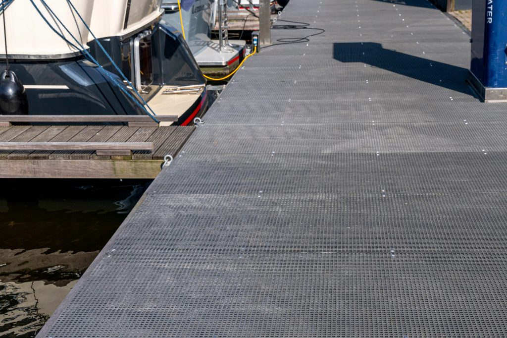 Drijvende steiger met antislip roostermatten in jachthaven, professioneel aangelegd door Bouma Waterwerken.